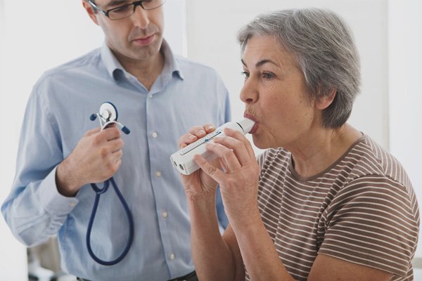 Doctor assisting a patient with respiratory therapy